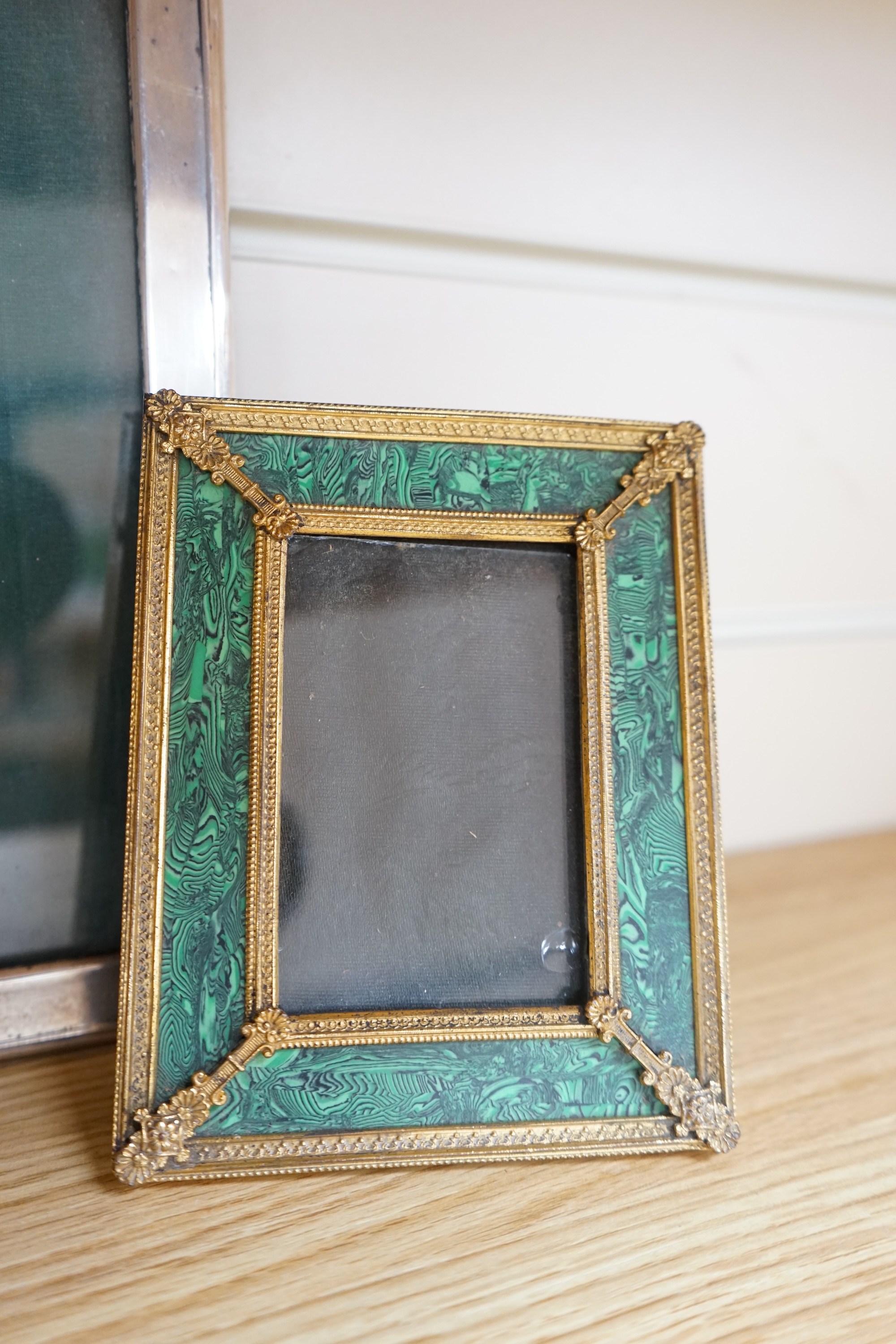 An early 20th century silver mounted photograph frame and a faux malachite gilt easel frame, largest 24cm high. Condition - fair